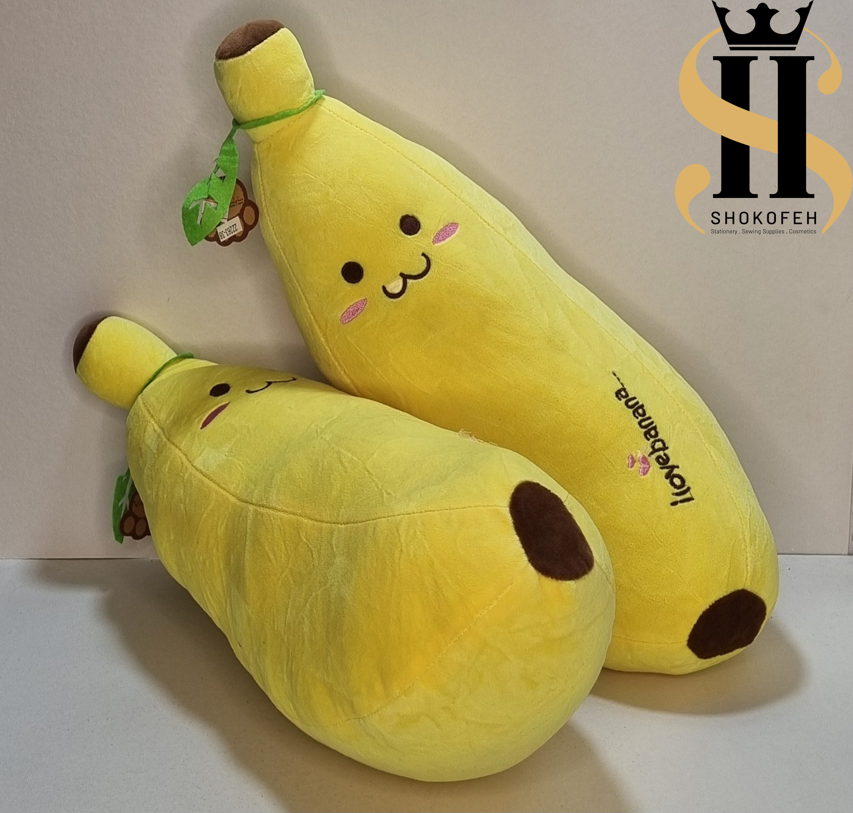 دو عدد عروسک موز بالشتی زرد بزرگ و کوچک با چهره خندان و لپهای صورتی گلدوزی شده